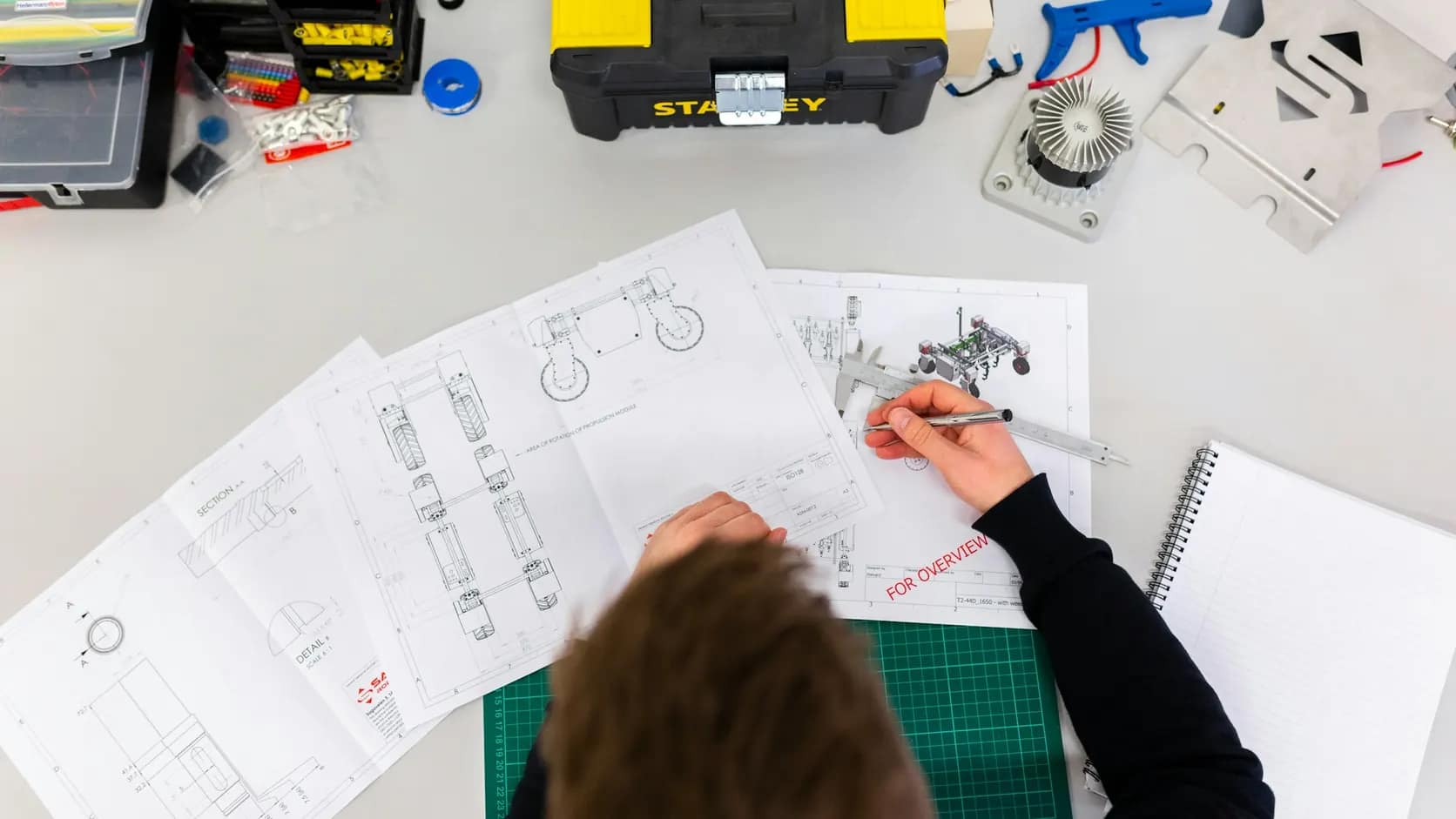 Projeto VRF para ambientes comerciais e industriais | Schaltz Engenharia Profissional desenvolvendo desenhos técnicos sobre a mesa de trabalho